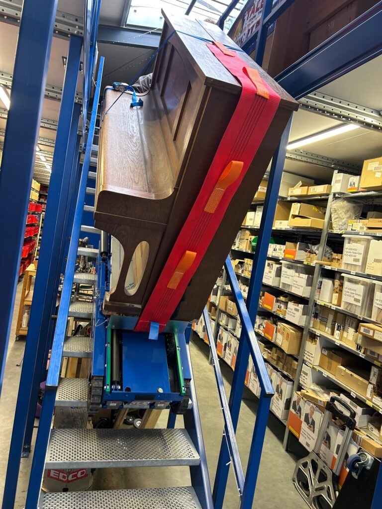 Ein Klavier wird mit einem Pianoplan eine Treppe hinunter gefahren.
