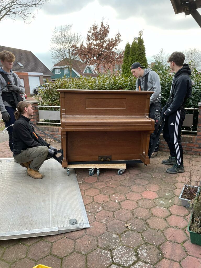 Ein Klavier wird ein einen LKW verladen